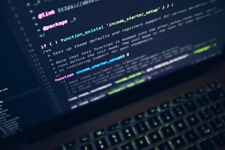 Écran de laptop affichant du code, ambiance sombre et professionnelle
